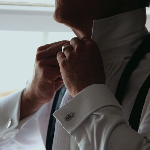 A man buttoning his collar