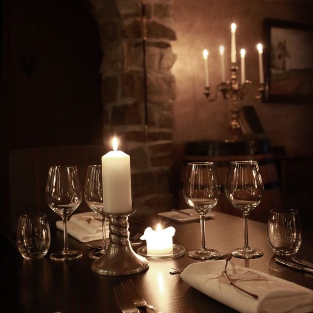 Set table with lit candles in Klosterkjelleren