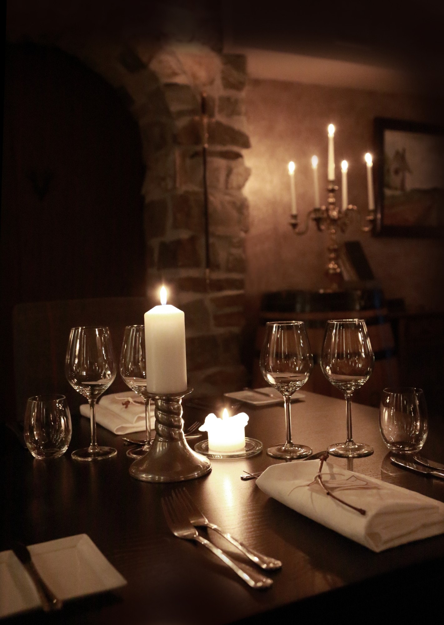 Set table with lit candles in Klosterkjelleren