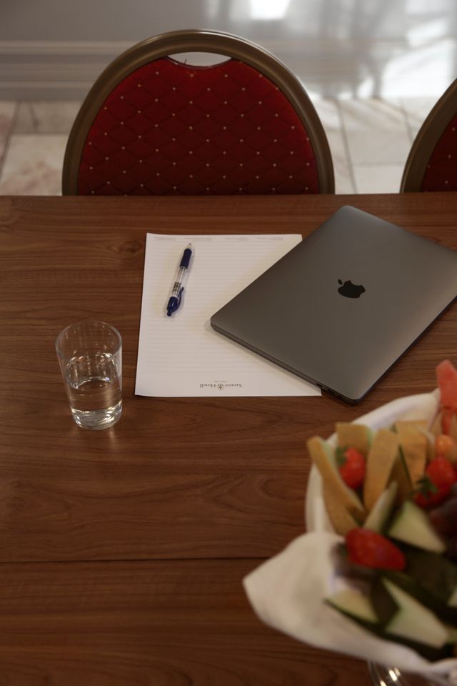 Konferansebord med laptop og papirer