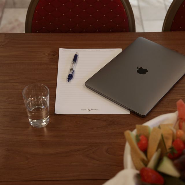 Konferansebord med laptop og papirer